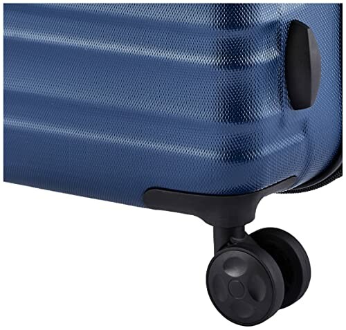 Close-up of a blue suitcase with a wheel.