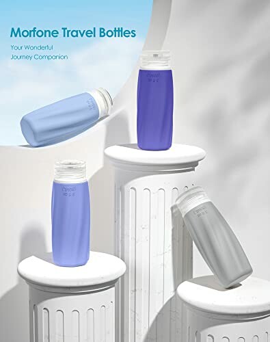 Set of Morfone travel bottles in blue and gray on pedestals.